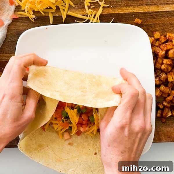 High-Protein Breakfast Burrito with Crispy Potato Filling 10 Folding in the tortilla over the filling.