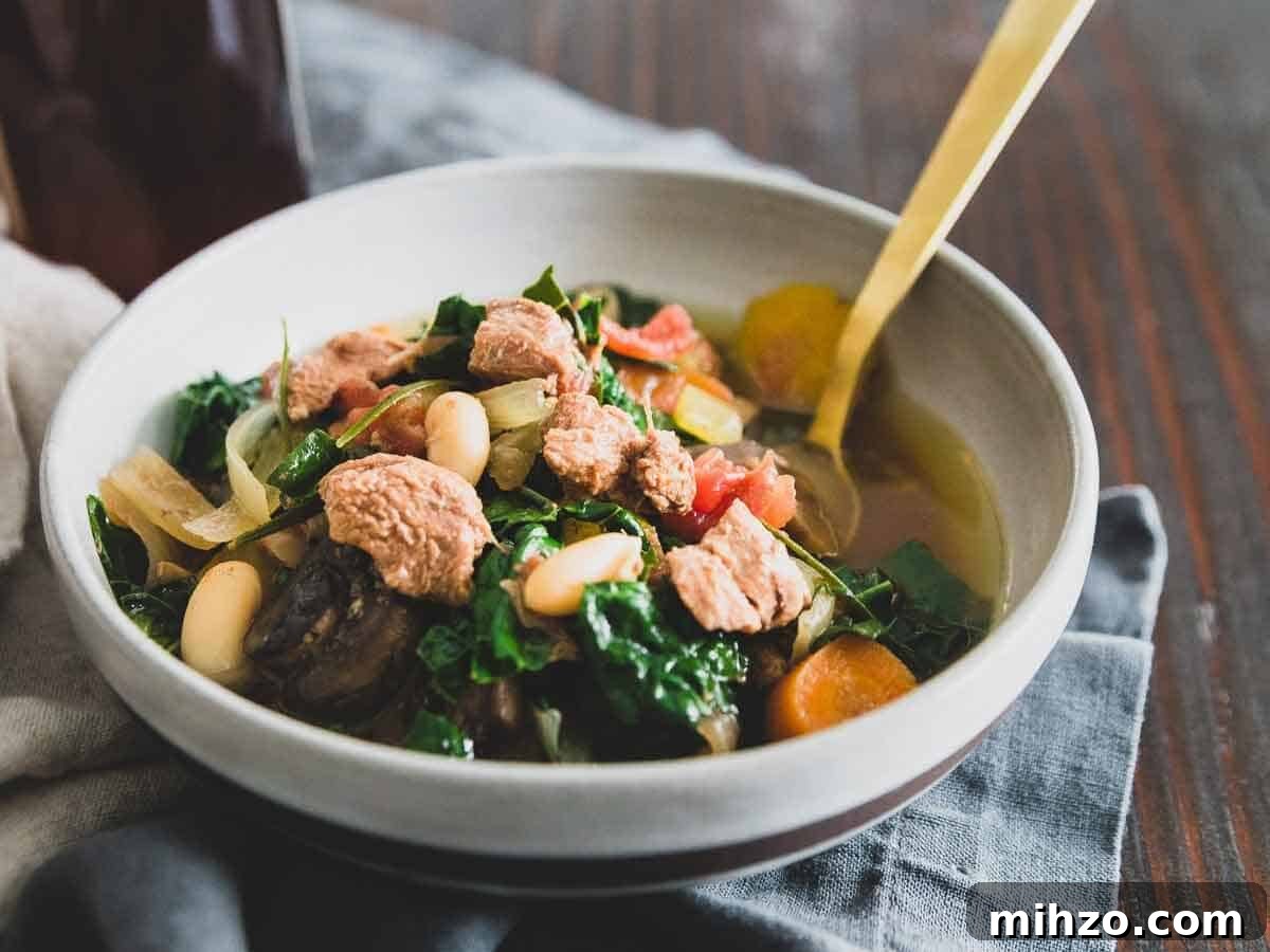 Slow cooker lamb stew in a bowl with a spoon.