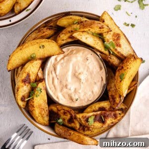 Crispy Oven-Baked Potato Wedges with Smoky Chipotle Sauce 18 potato wedges surrounding a bowl of chipotle sauce