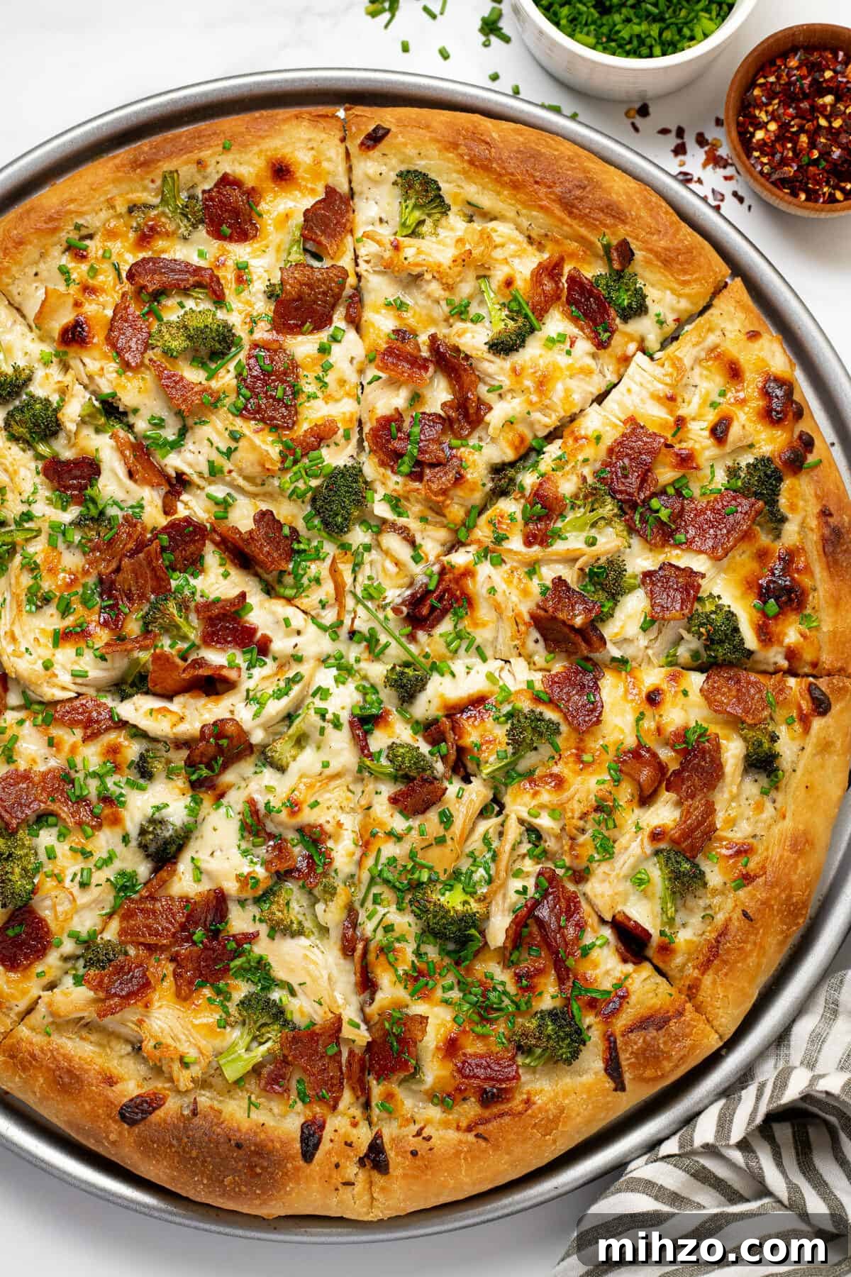 15-Minute Garlic Parmesan Sauce Recipe for Quick Dinners 10 Overhead shot of a chicken alfredo pizza on a pizza pan garnished with fresh chives