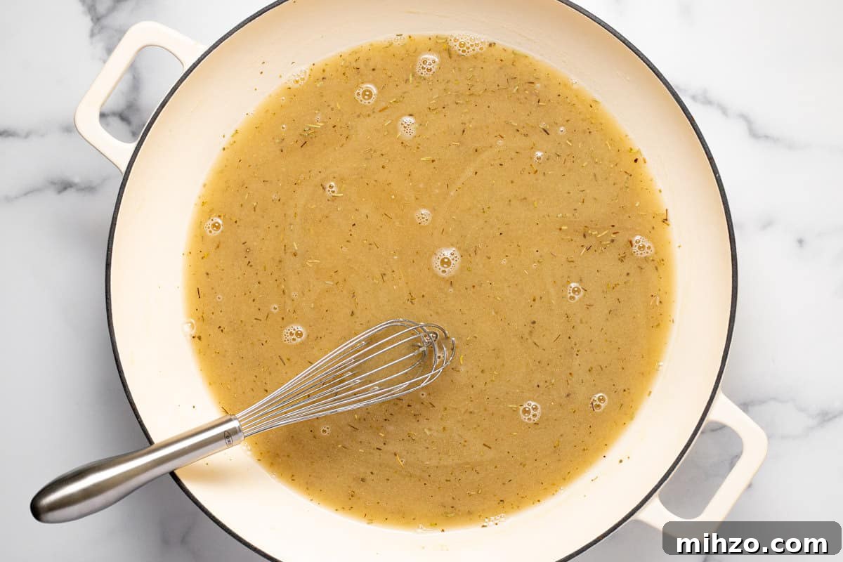 15-Minute Garlic Parmesan Sauce Recipe for Quick Dinners 6 Large white sauté pan filled with ingredients to make Parmesan cream sauce