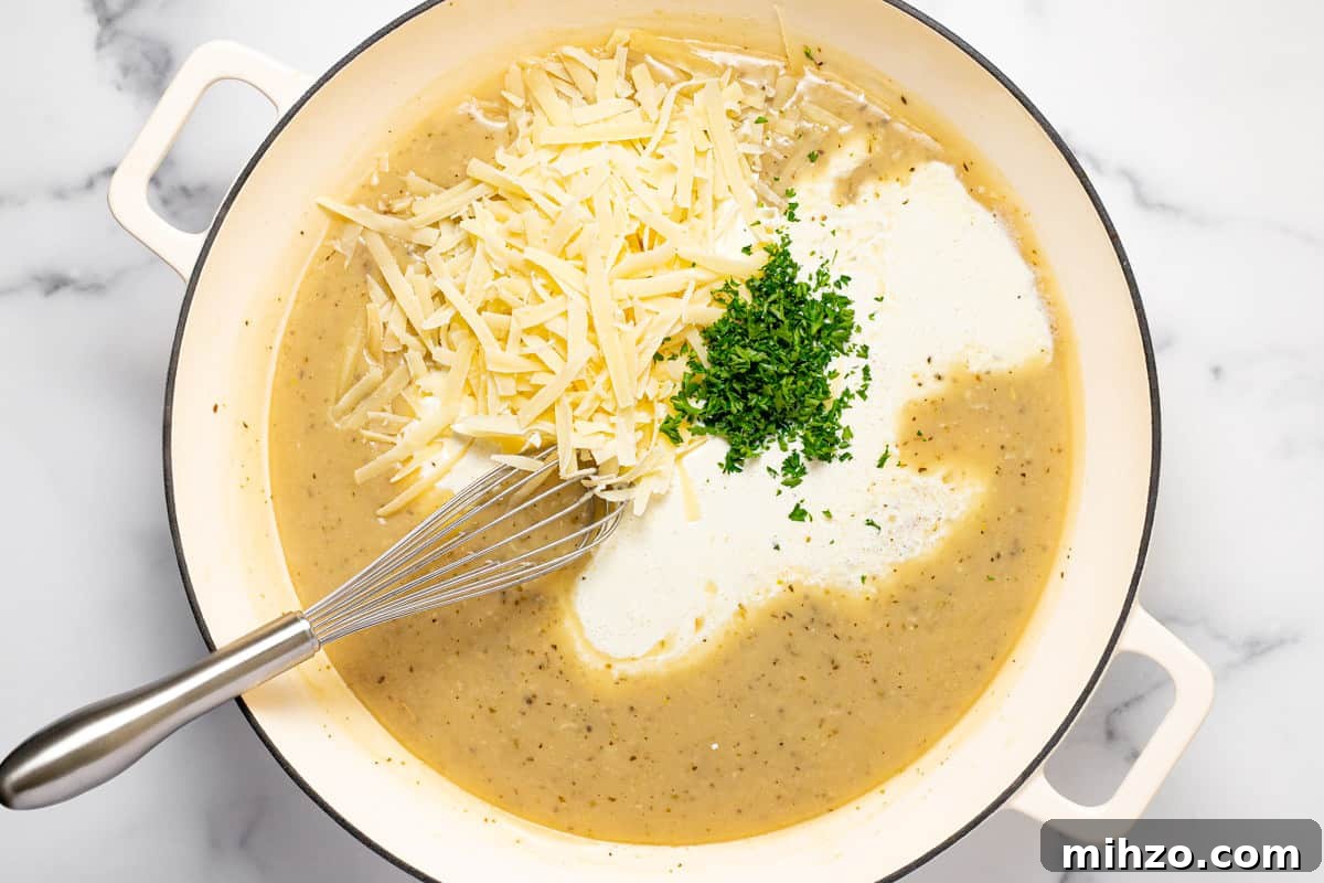 15-Minute Garlic Parmesan Sauce Recipe for Quick Dinners 7 Large white sauté pan filled with ingredients to make Parmesan cream sauce