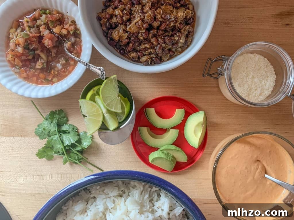 Protein-Packed Vegetarian Black Bean Burrito Bowl Recipe 9 All the toppings on a wood counter including avocado and more.