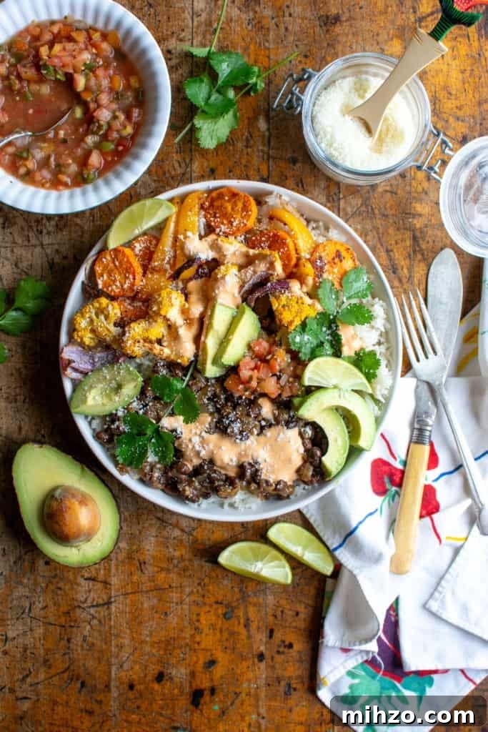 Protein-Packed Vegetarian Black Bean Burrito Bowl Recipe 10 A burrito bowl on a wood table next to half an avocado