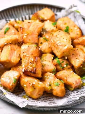 Air fryer salmon bites on a parchment-lined plate.