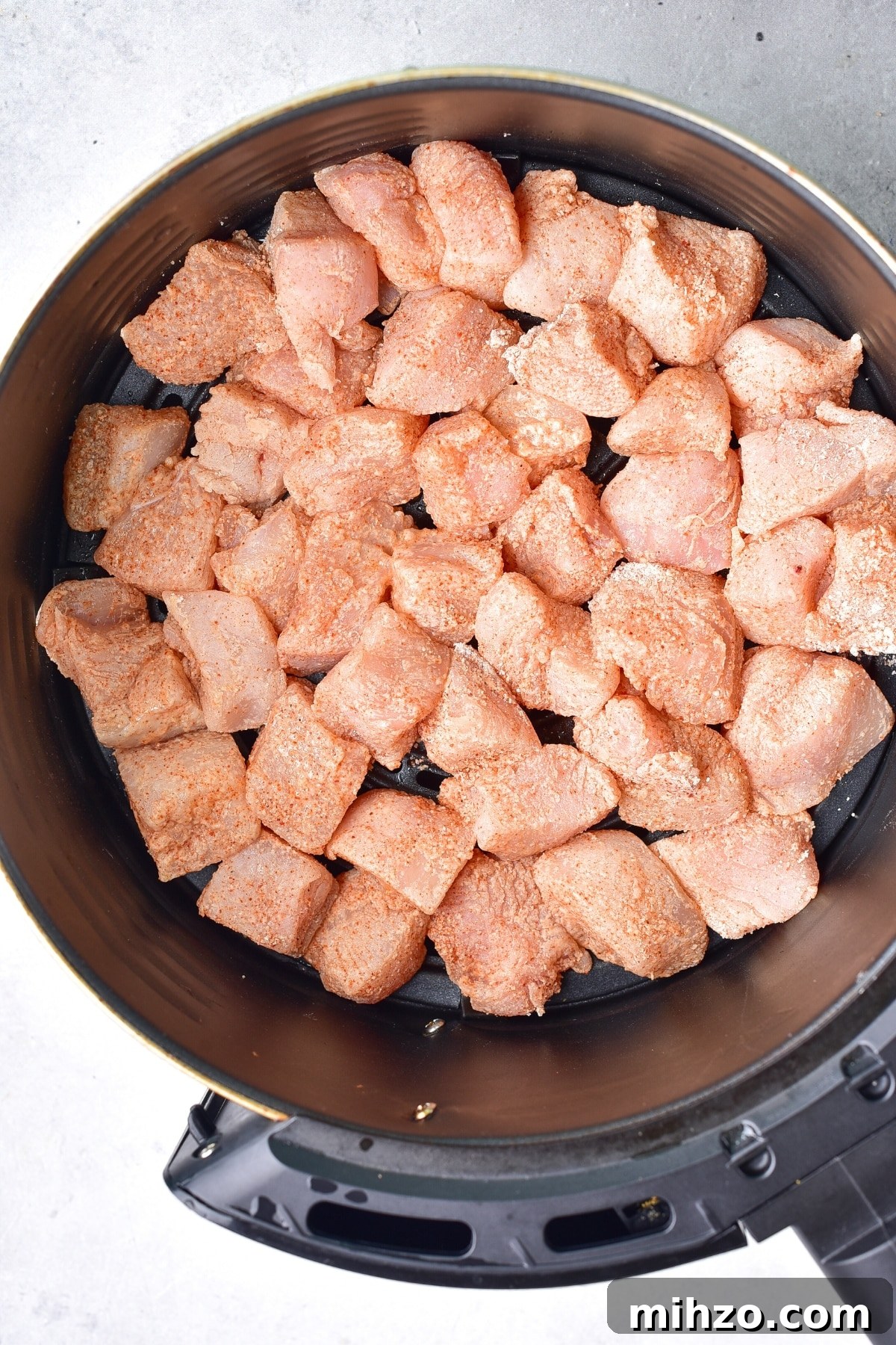 How to Make Air Fryer Buffalo Chicken Bites (Gluten-Free, Dairy-Free) Raw chicken pieces in air fryer basket