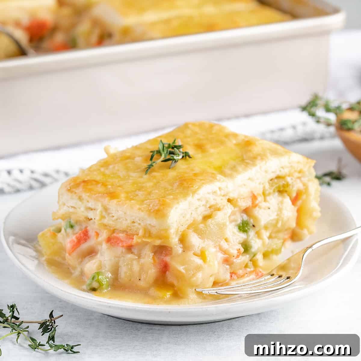 Hearty Vegetable Pot Pie Recipe with Flaky Crust 5 a serving of Vegetable Pot Pie on a white plate with a fork