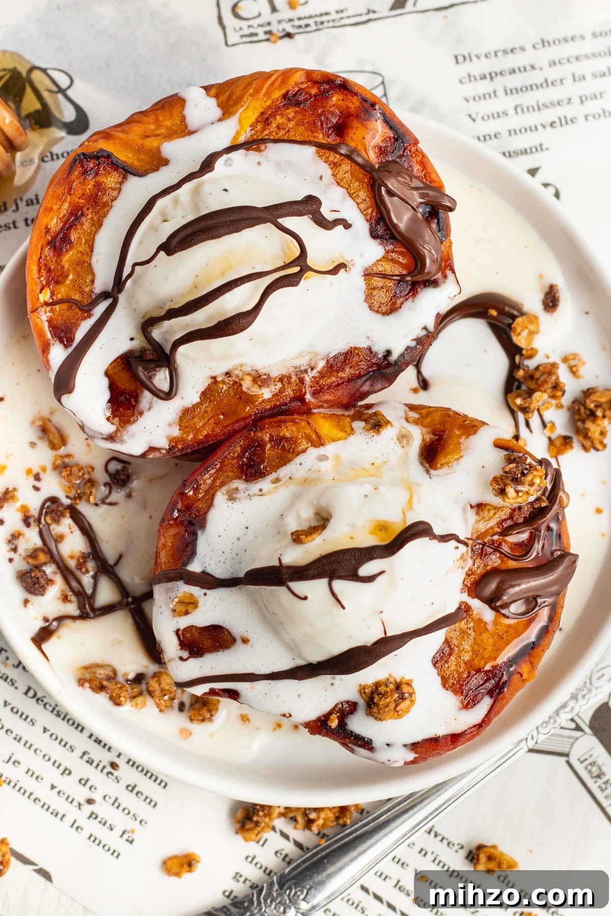 Crispy Air Fryer Peaches with Honey-Brown Sugar Glaze 2 Picture of air fryer peaches topped with ice cream, honey, chocolate drizzle and granola.