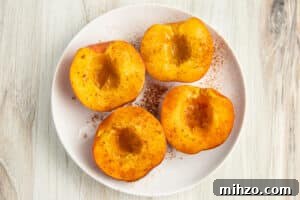 Crispy Air Fryer Peaches with Honey-Brown Sugar Glaze 10 Picture of 4 peach halves seasoned with honey and cinnamon.