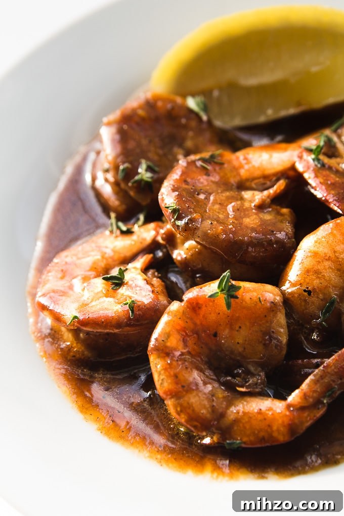 New Orleans BBQ Shrimp - Juicy shrimp in a buttery lemon Worcestershire sauce. New Orleans BBQ Shrimp on a serving platter