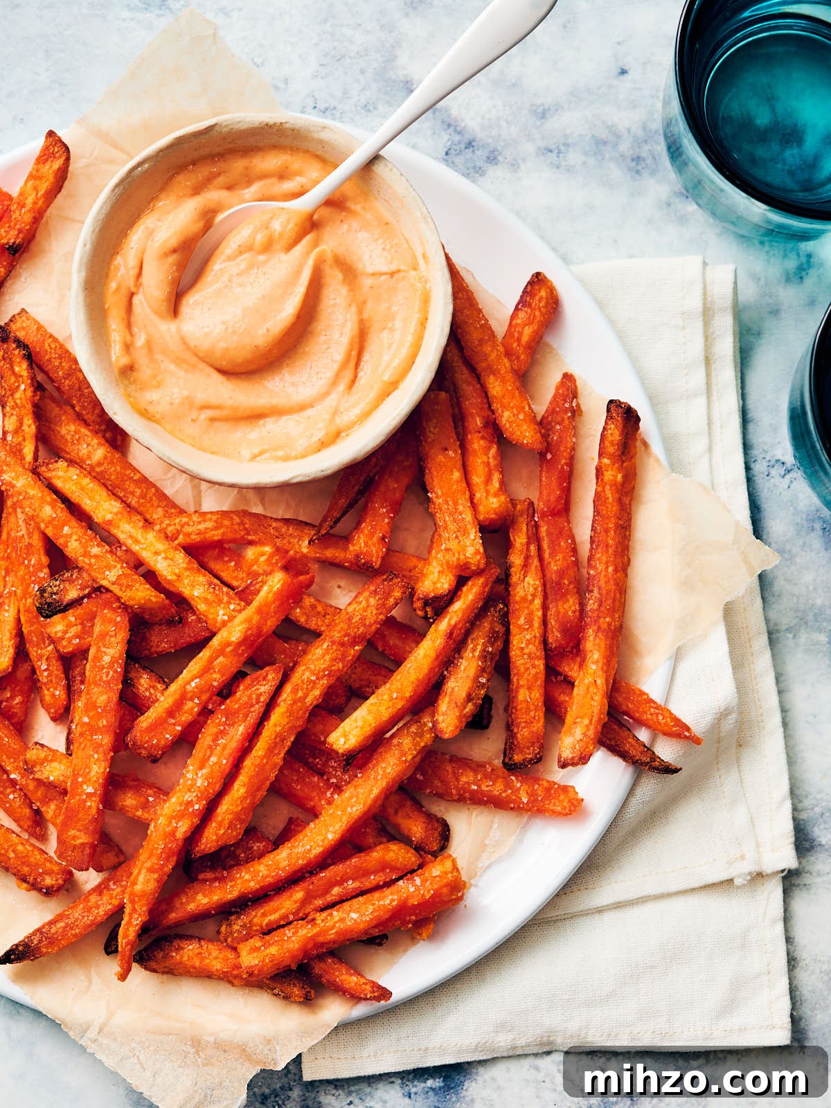 Quick Sriracha Aioli Recipe with 3 Ingredients 14 Easy Sriracha Aioli in a bowl served with sweet potato fries (yam fries) on a plate.