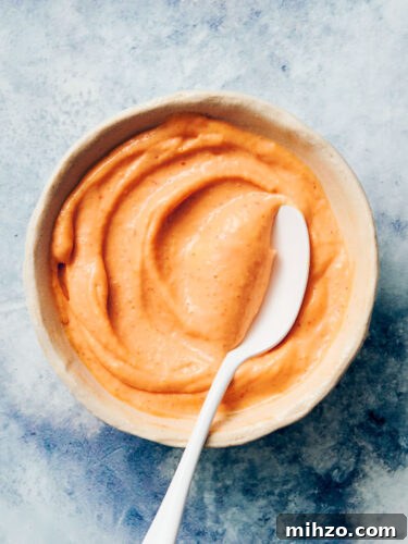 Quick Sriracha Aioli Recipe with 3 Ingredients 15 Easy Sriracha Aioli in a bowl with a spoon.