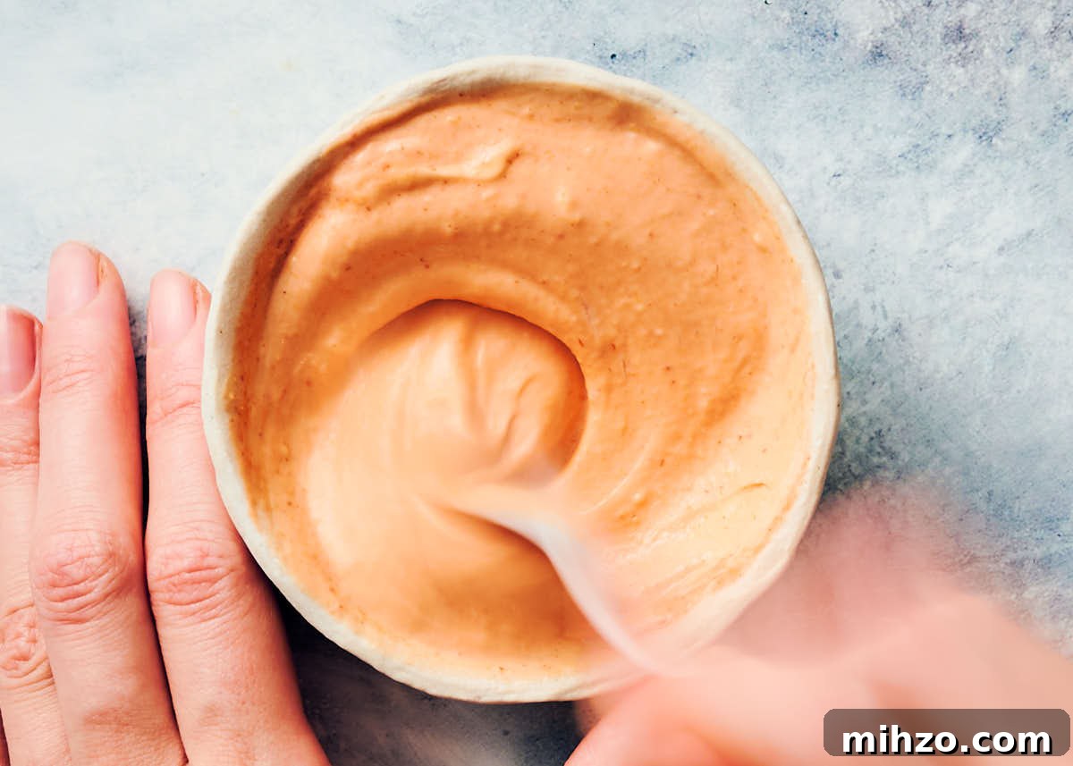 Quick Sriracha Aioli Recipe with 3 Ingredients 7 Stirring sriracha aioli ingredients together in a small bowl with spoon.