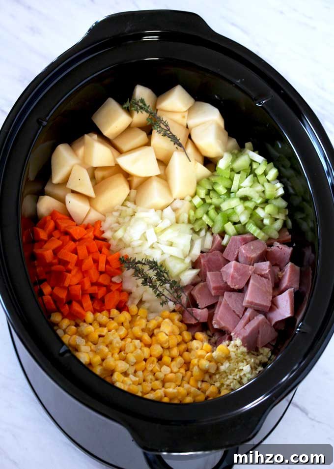 Slow Cooker Creamy Ham and Potato Soup Recipe 3 Pictured here is a slow cooker filled with cubed potatoes, ham, chopped onions, celery, carrots, corn, minced garlic and thyme sprigs.