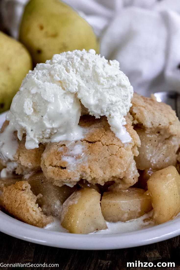 This pear cobbler is a fall twist on one of the most easy going desserts around. Tender pears, golden topping, and a perfect cobbler are all yours. #cobblerrecipes #pearcobbler pear cobbler with vanilla ice cream on top