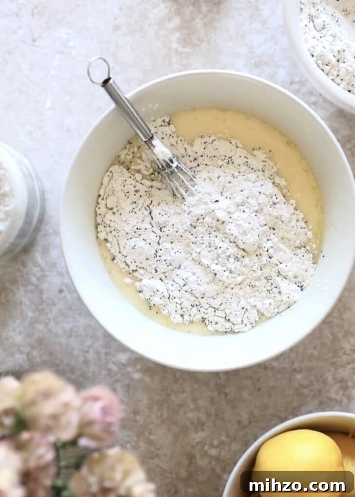 Ricotta Lemon Poppy Seed Muffins with Zesty Citrus Glaze 11 Bowl with wet ingredients topped with flour.