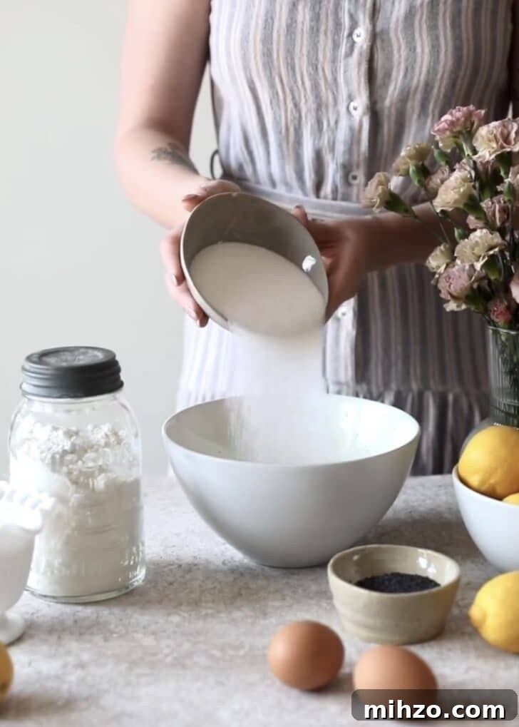 Ricotta Lemon Poppy Seed Muffins with Zesty Citrus Glaze 5 Pouring sugar into a bowl.