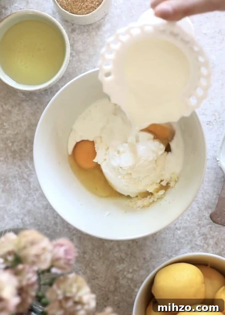 Ricotta Lemon Poppy Seed Muffins with Zesty Citrus Glaze 9 Pouring milk into a bowl.