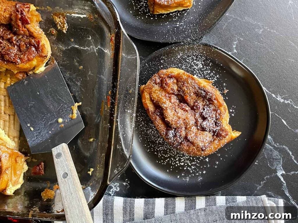 Decadent Panettone French Toast Recipe for Brunch 11 Slices of overnight maple bacon baked french toast on black plates garnished with powdered sugar.