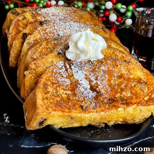 Decadent Panettone French Toast Recipe for Brunch 13 Slices of panettone French toast garnished with powdered sugar, whipped cream, and maple syrup on a dark plate.