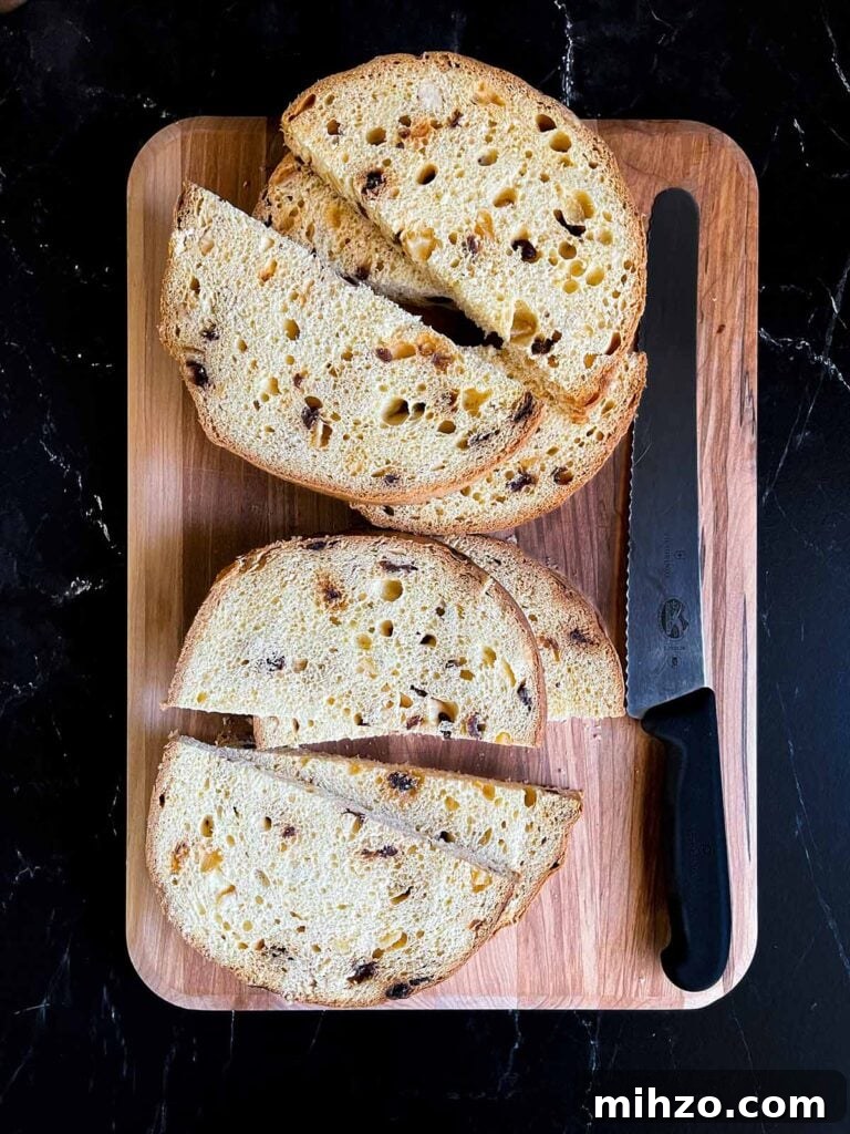 Decadent Panettone French Toast Recipe for Brunch 4 Panettone sliced into half moon slices on a wooden board.