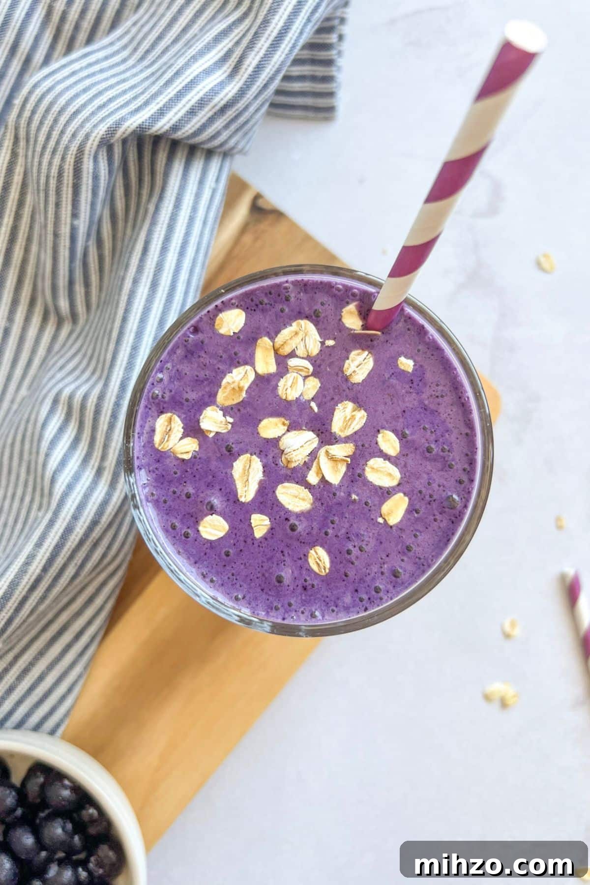 Thick, refreshing, and packed with 35 grams of protein, this blueberry smoothie makes the easiest healthy breakfast to take on the go. Blueberry protein smoothie in a glass with a straw.