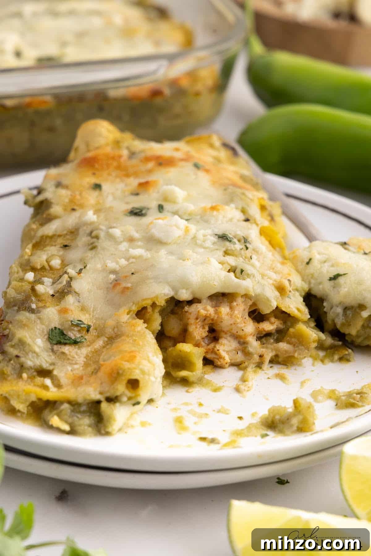 Front view of a plate of Green Chicken Enchiladas with a bite taken from it.