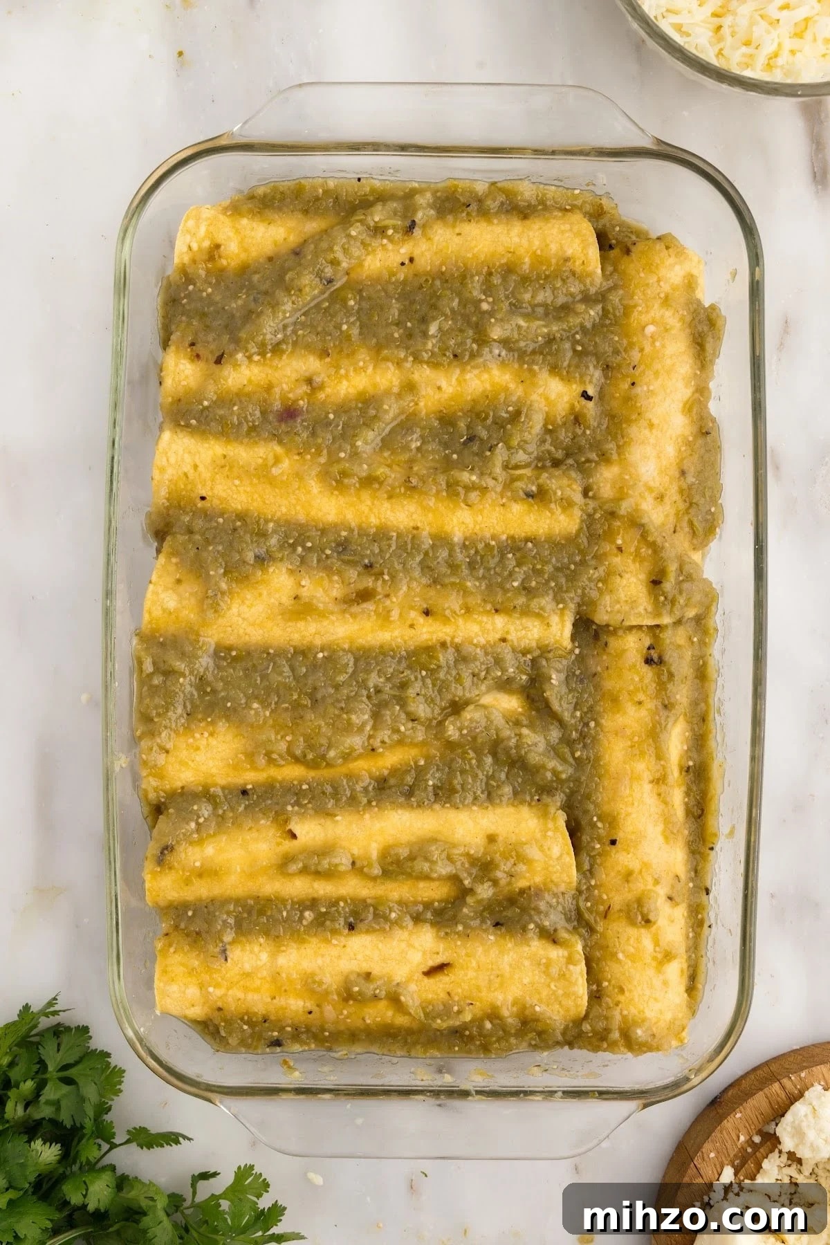Enchilada sauce poured on top of the Green Chicken Enchiladas.