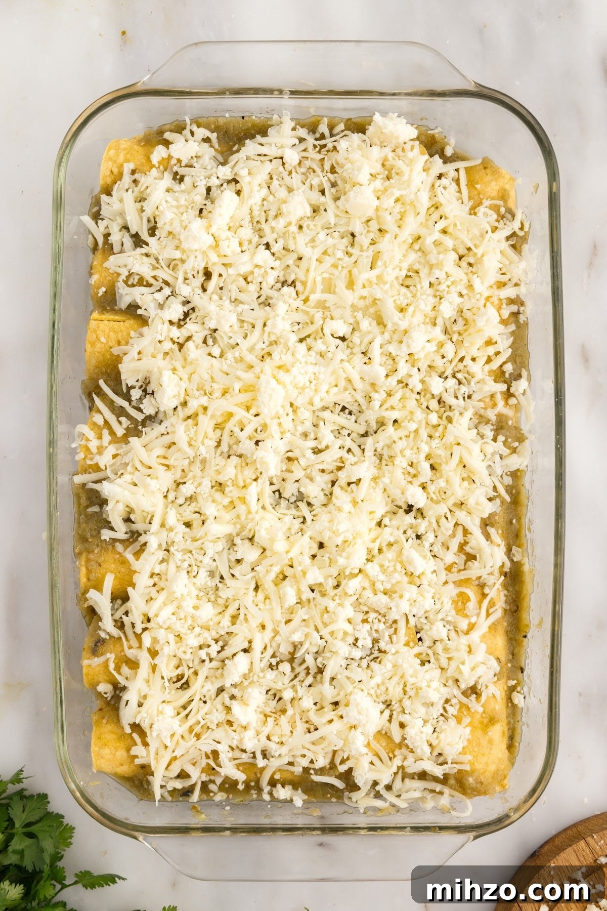Cheese added to the top of the Green Chicken Enchiladas.