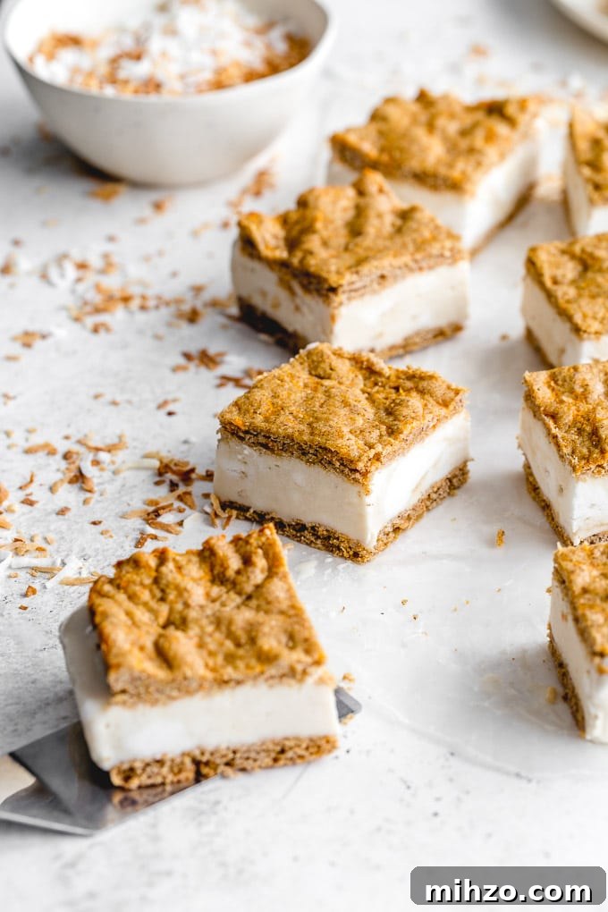 Carrot cake ice cream sandwiches cut into squares and arranged on a light surface.