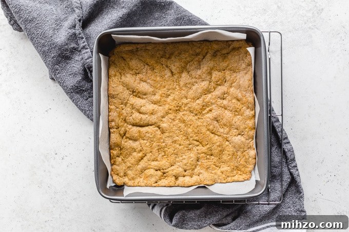 Carrot cake cookie layer baked up in a square pan.