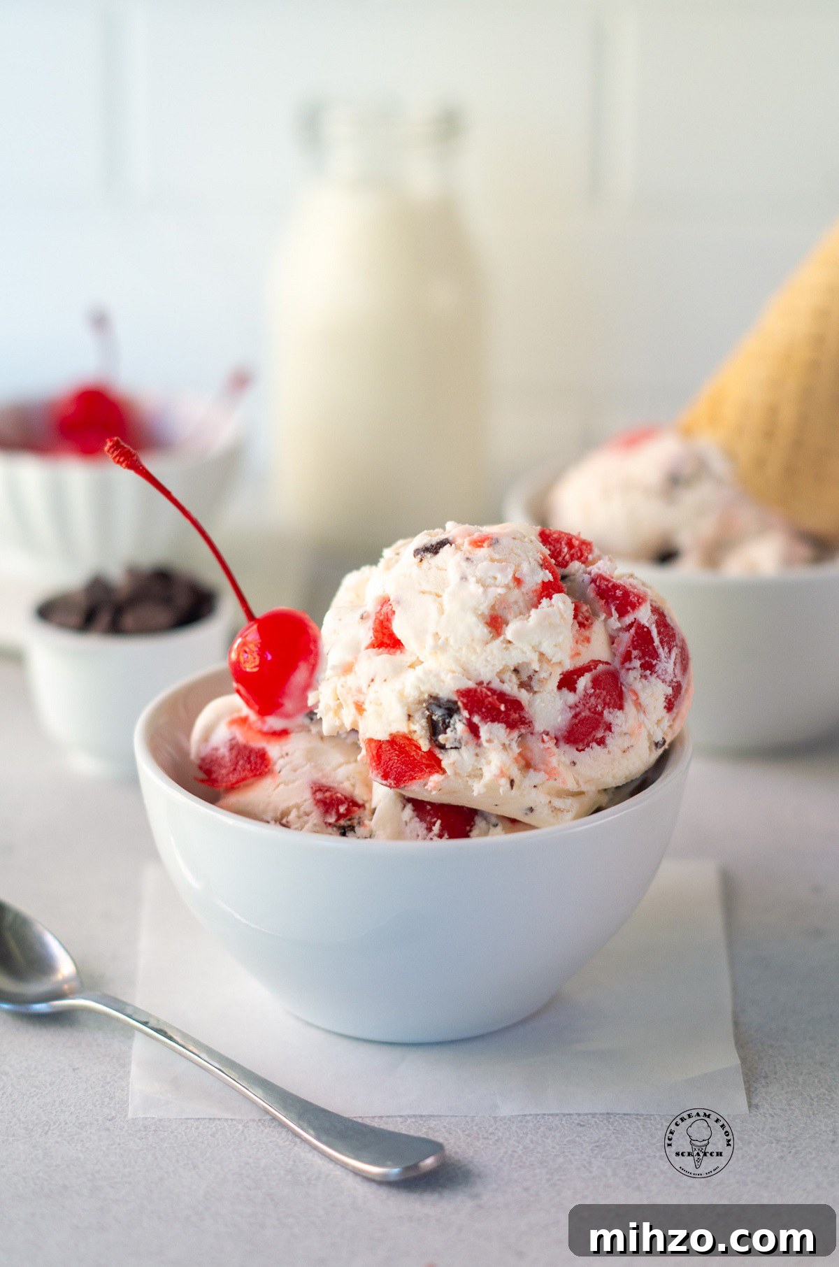 A bowl of homemade cherry cordial ice cream with a cherry on top