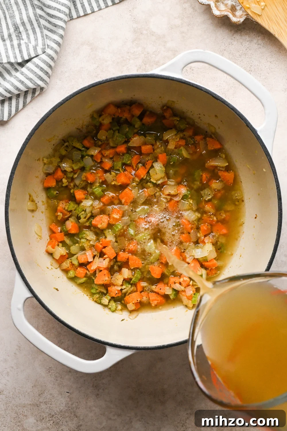 Delicious Dairy-Free Chicken and Broccoli Soup Recipe 10 How to make Chicken and Broccoli Soup: A hand pouring chicken broth into the soup pot.