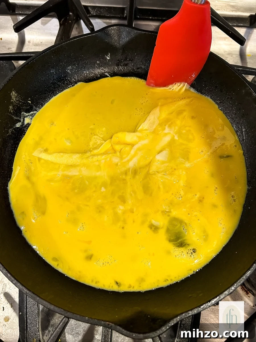 Sourdough Breakfast Sandwich Ideas for Quick Morning Meals 7 Scrambling fluffy eggs in a small skillet.