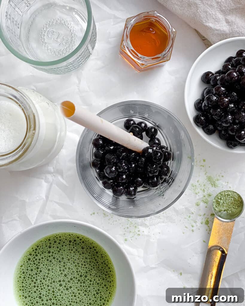 ingredients for Matcha Boba Tea (Green Milk Tea) measured out against a white surface