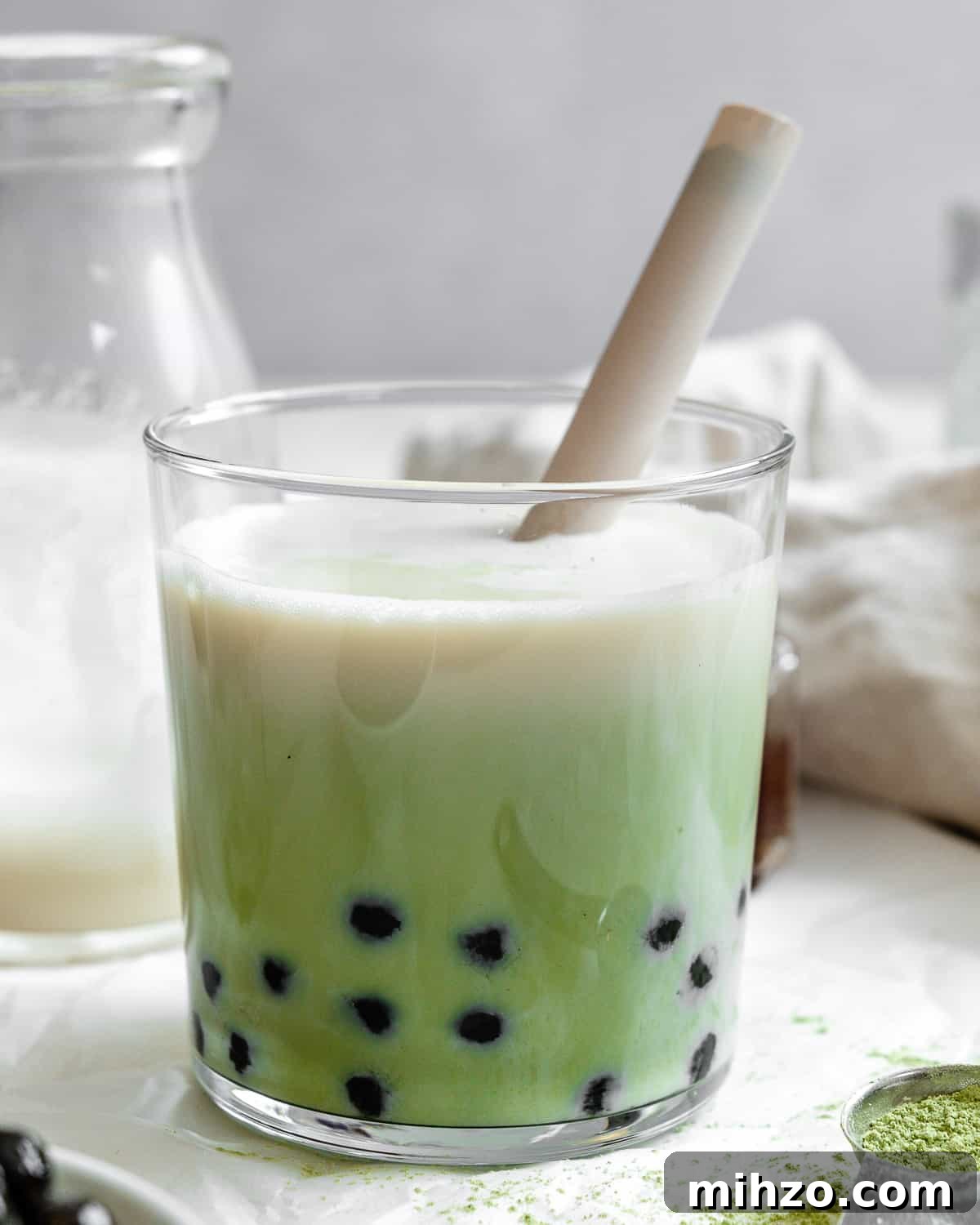 completed Matcha Boba Tea (Green Milk Tea) in a glass against a light background