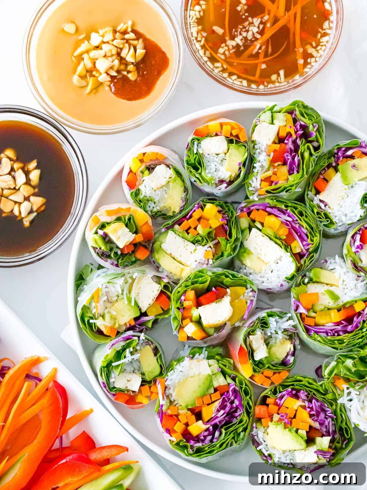 Vietnamese vegetarian summer rolls with rainbow veggies with peanut sauce, hoisin sauce, and dipping sauce