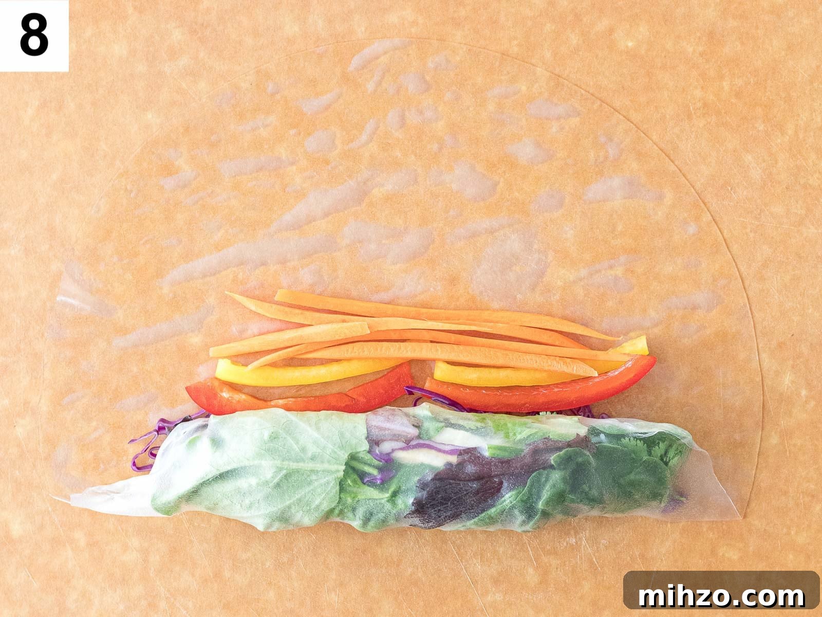 wrapping summer rolls with rice paper and carrots and pepper