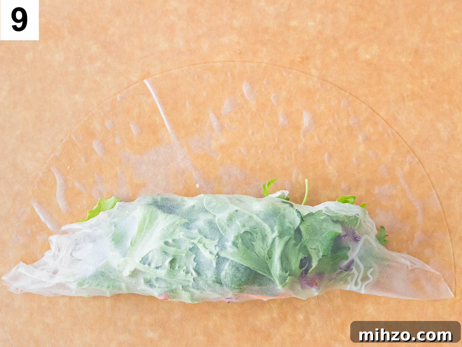 summer roll being rolled up with a rice paper wrapper