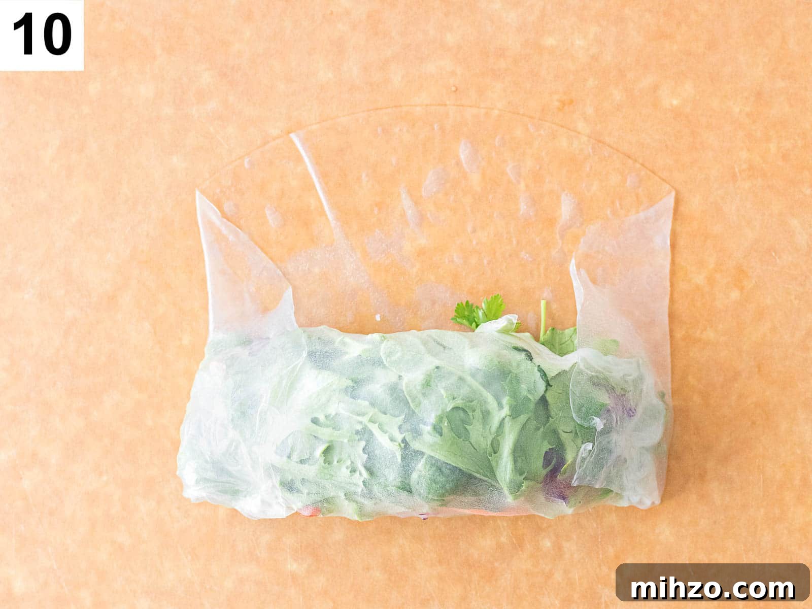 summer roll being rolled up with a rice paper wrapper