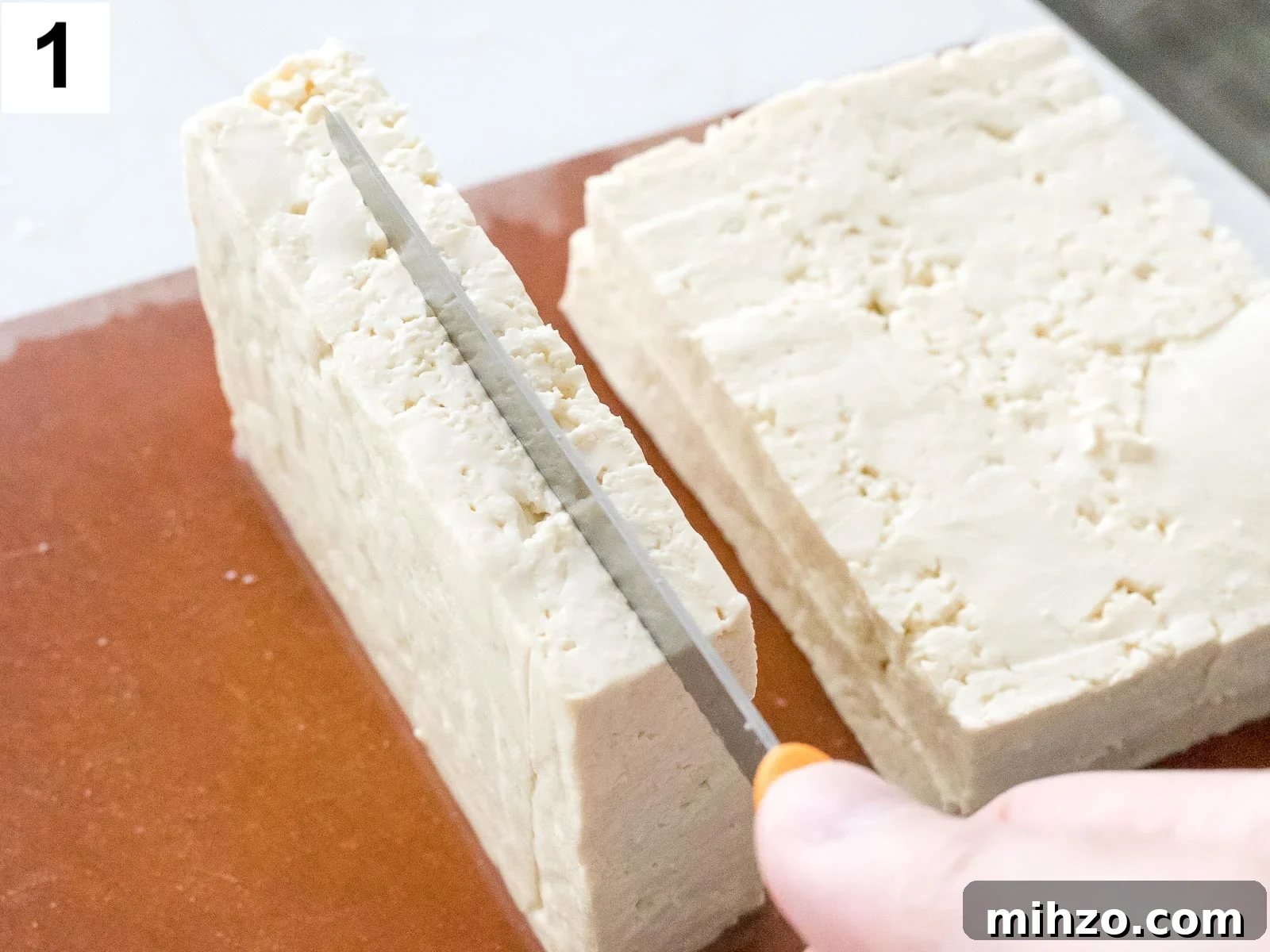 close up of tofu being cut with a knife
