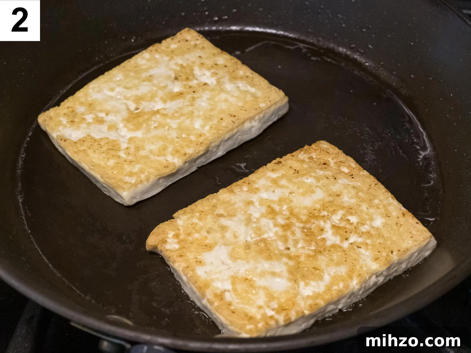 tofu being pan fried until golden brown