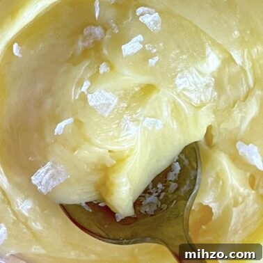 Whipped Honey Butter Recipe: Smooth, Spreadable & Quick 13 A spoon dipping into a bowl of honey butter.