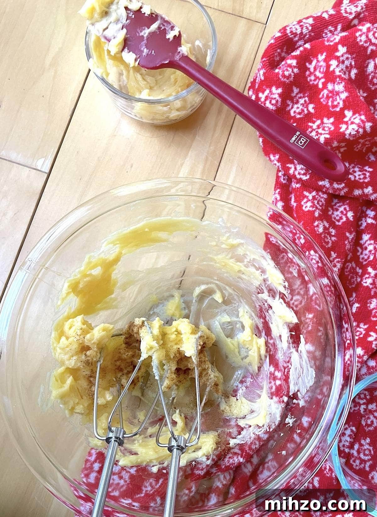 Whipped Honey Butter Recipe: Smooth, Spreadable & Quick 6 A small bowl of honey butter being whipped with an electric mixer, with cinnamon and vanilla extract being added to it after splitting from the plain honey butter.