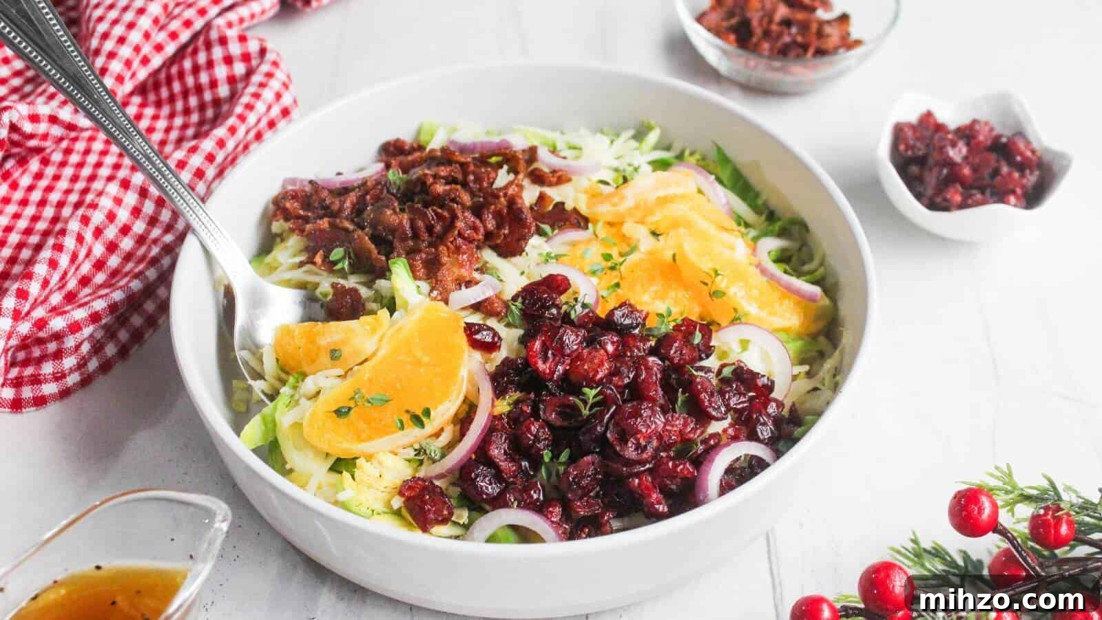 24 Brussels Sprouts Recipes That Even Non-Veggies Will Love 3 A white bowl filled with salad containing orange slices, dried cranberries, red onion, shredded greens, and bacon bits, with a fork resting inside. Small bowls of toppings and dressing nearby.