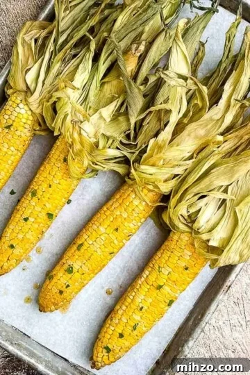 An overhead picture of smoked corn on the cob on a baking sheet.