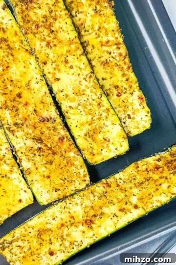 Smoked zucchini slices on a baking sheet, capturing the golden-brown char marks and juicy texture of each slice.