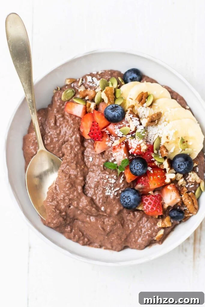 Decadent Chocolate Chia Pudding Recipe for Breakfast & Dessert 2 A bowl of chocolate chia seed pudding topped with fruit, nuts, and coconut.