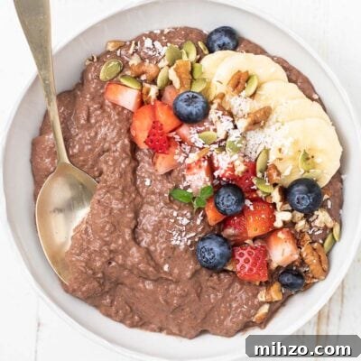 Decadent Chocolate Chia Pudding Recipe for Breakfast & Dessert 8 A bowl of chocolate chia seed pudding topped with berries, bananas, and nuts.