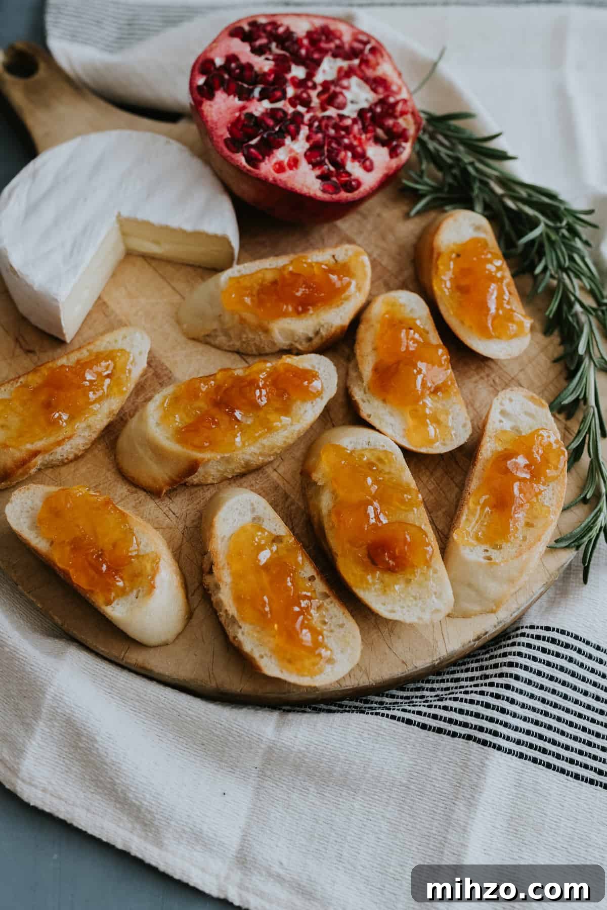brie bruschetta in the process of being assembled with apricot preserves on top.